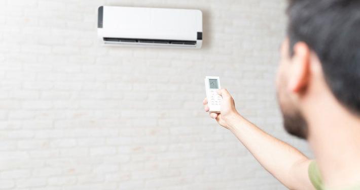 man with remote control for a heat pump